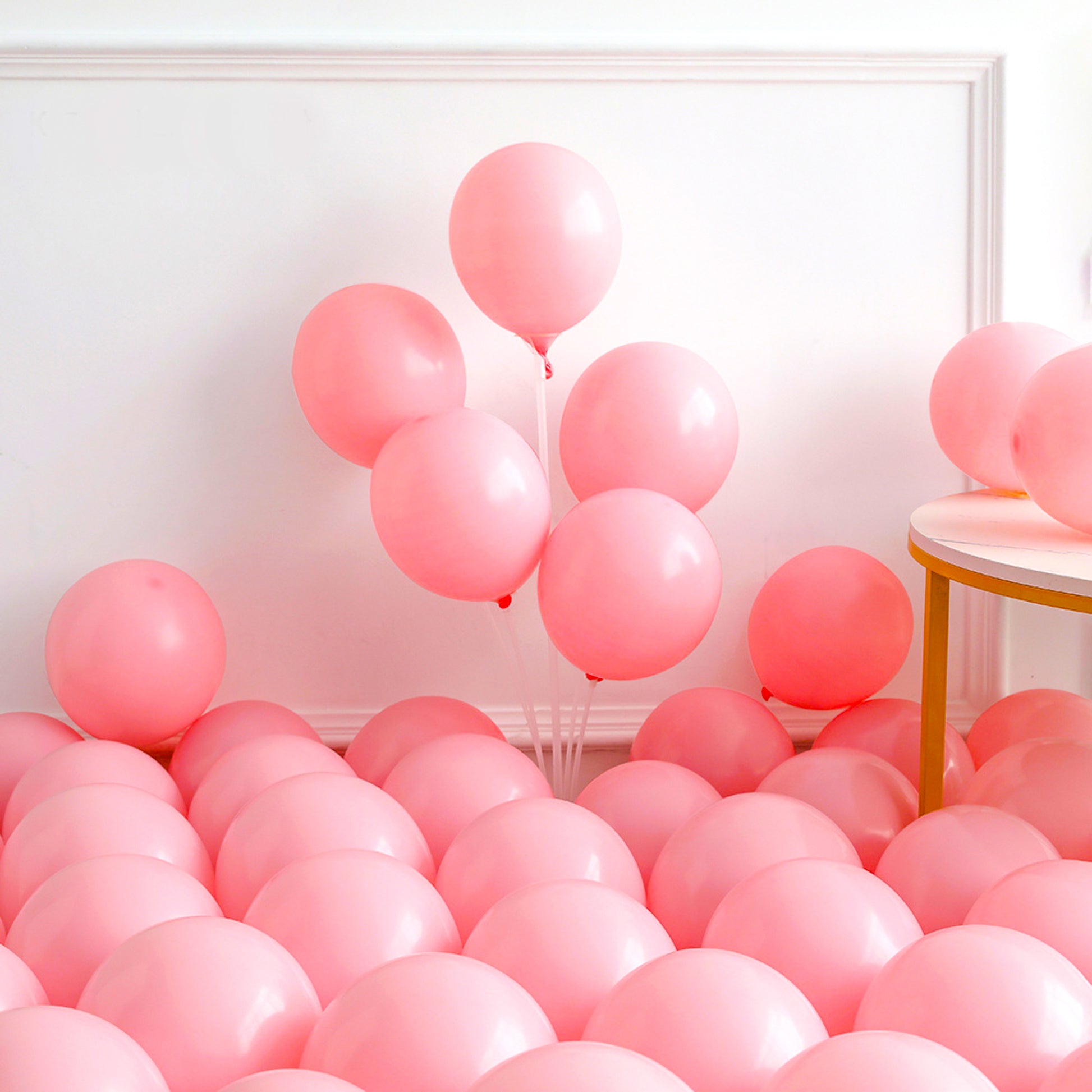 148 Piece Universal Gender Reveal/ Baby Shower Luxury Balloon Kit displayed with soft pink balloons arranged elegantly against a white wall, featuring floating and floor-placed balloons creating a dreamy, romantic atmosphere perfect for celebrations.