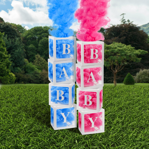 DIY -Gender Reveal Smoke Box Trend showing blue and pink smoke emerging from baby blocks outdoors.