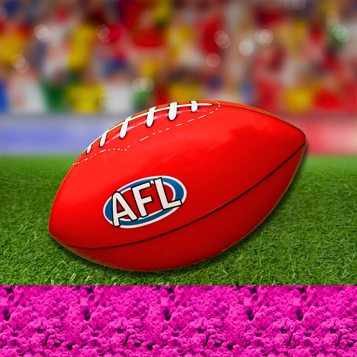 Sports Gender Reveal AFL Ball featuring a classic red Australian Rules football with AFL logo resting on green turf, with vibrant pink powder effect below, set against a colorful bokeh background, perfect for gender reveal celebrations.