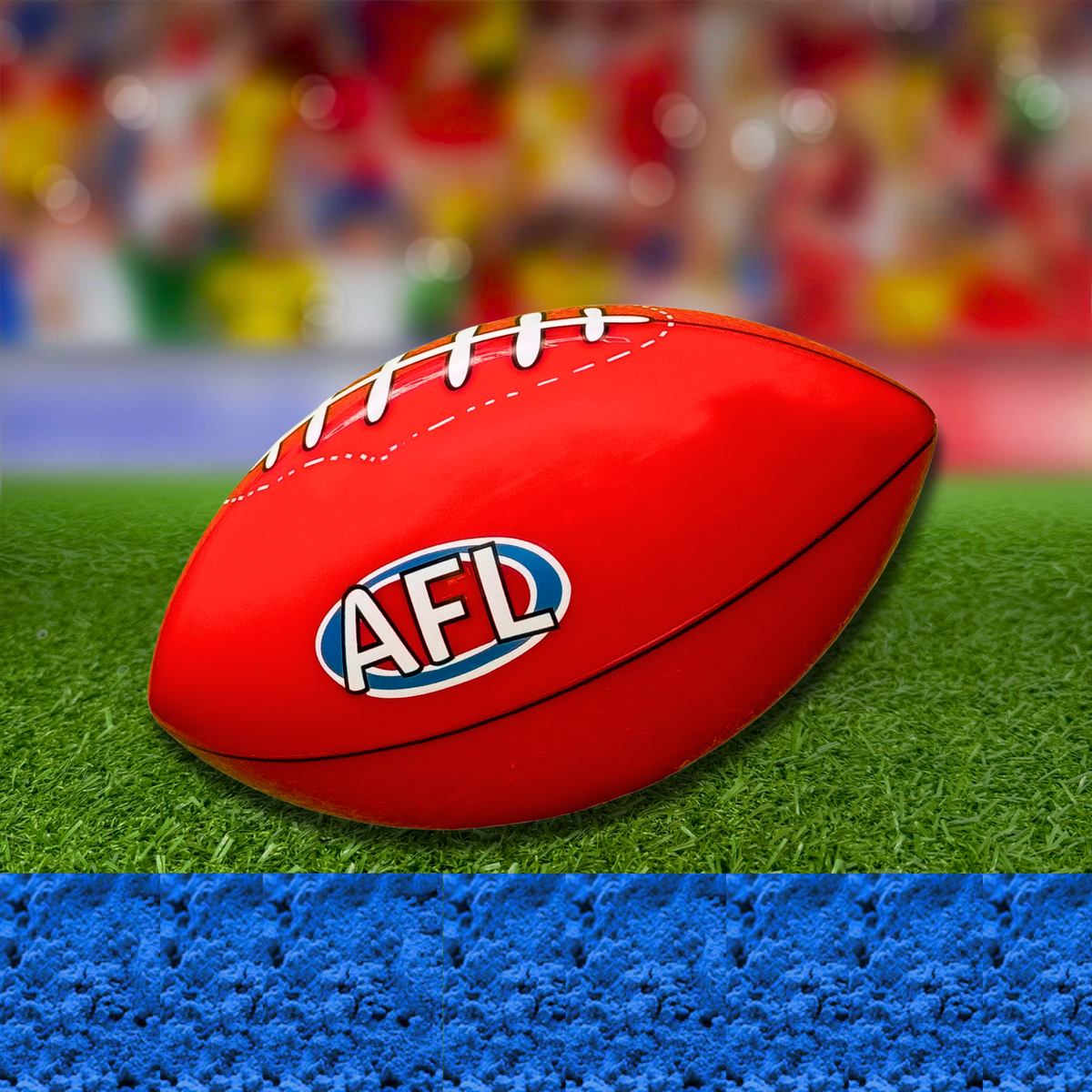 Sports Gender Reveal AFL Ball: Traditional red Australian Rules football with AFL logo resting on artificial grass against colorful blurred background, perfect for gender reveal celebrations