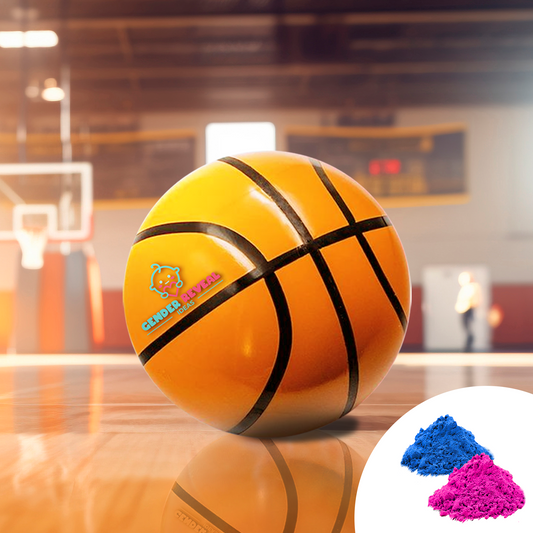 Gender Reveal Basketball shown on indoor basketball court with blue and pink powder packets, featuring traditional orange basketball with black stripes and company logo, photographed in professional sports facility setting with basketball hoop in background