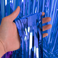 Gender Reveal Foil Party Curtain showing shiny blue metallic fringes held in hand, perfect for party decoration backdrop.