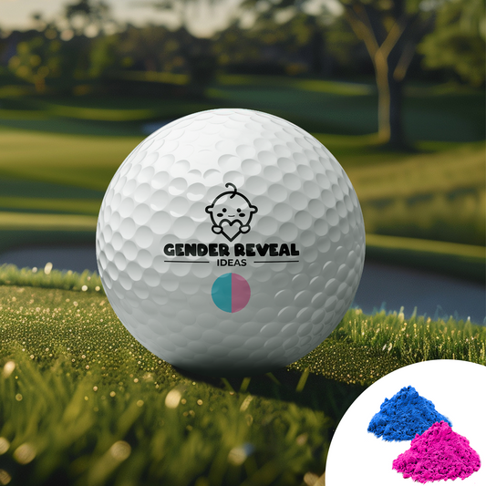 Gender Reveal Golf Ball displayed on lush green grass with brand logo and baby icon, featuring pink and blue powder burst insert, set against a scenic golf course backdrop at sunset with trees in the background