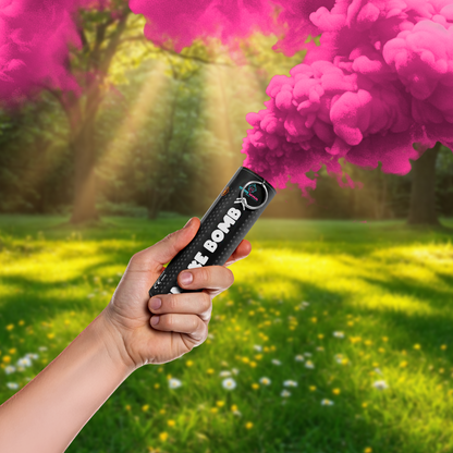 Hand holding a Gender Reveal Smoke Bomb releasing vibrant pink smoke in a sunlit outdoor setting.