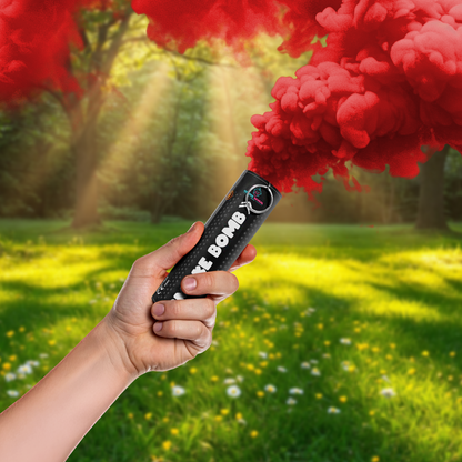 Hand holding a Gender Reveal Smoke Bomb emitting vibrant red smoke in a sunlit outdoor setting.